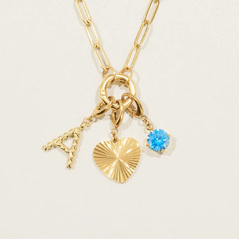 The Keepsake Necklace with an initial, a fluted heart and a birthstone charm